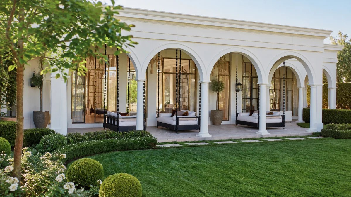 Sun-washed stucco, terracotta roof tiles, local basalt, dark timber shutters, and tropical greenery create a warm, timeless character.
